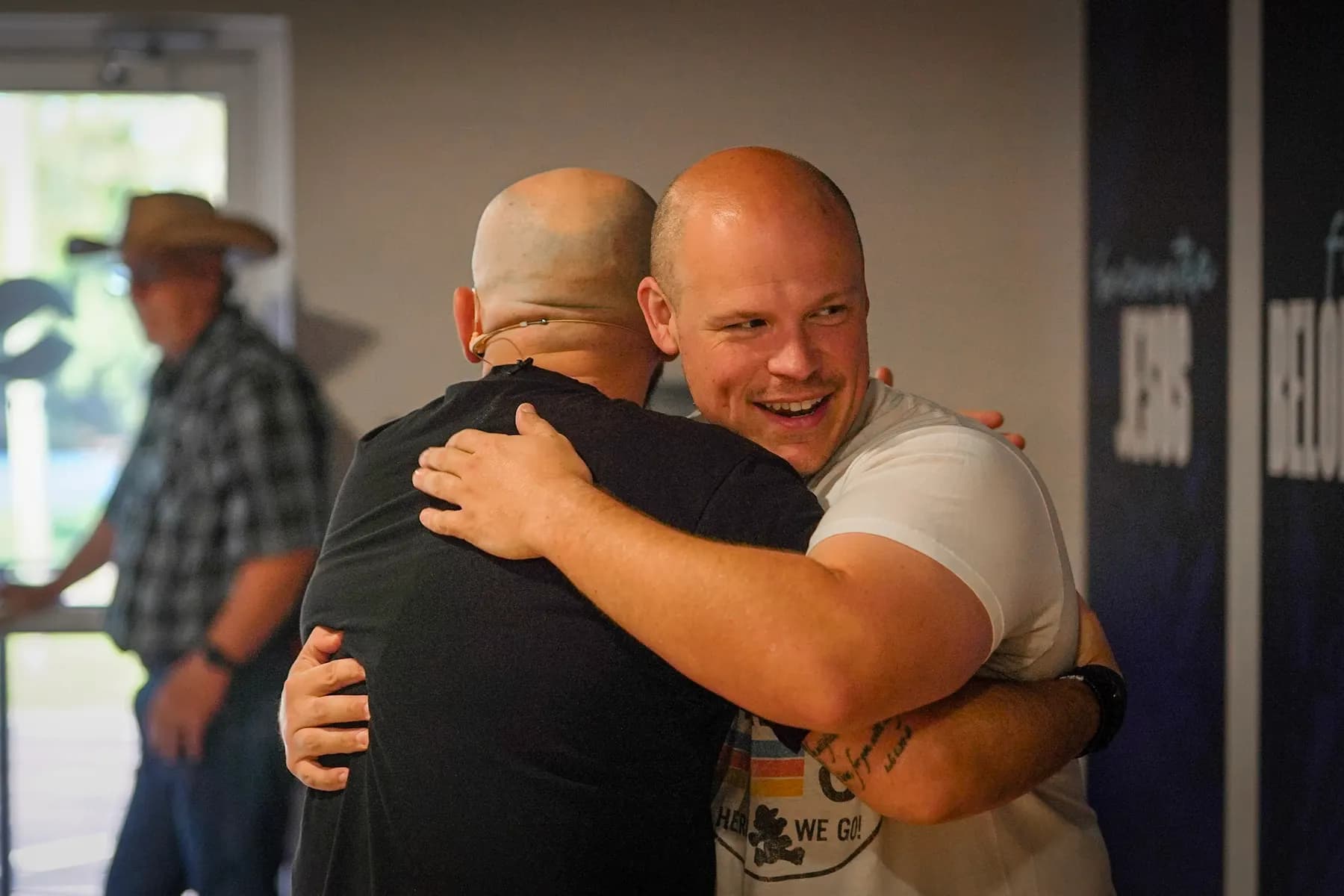 Two men greeting each other at the door