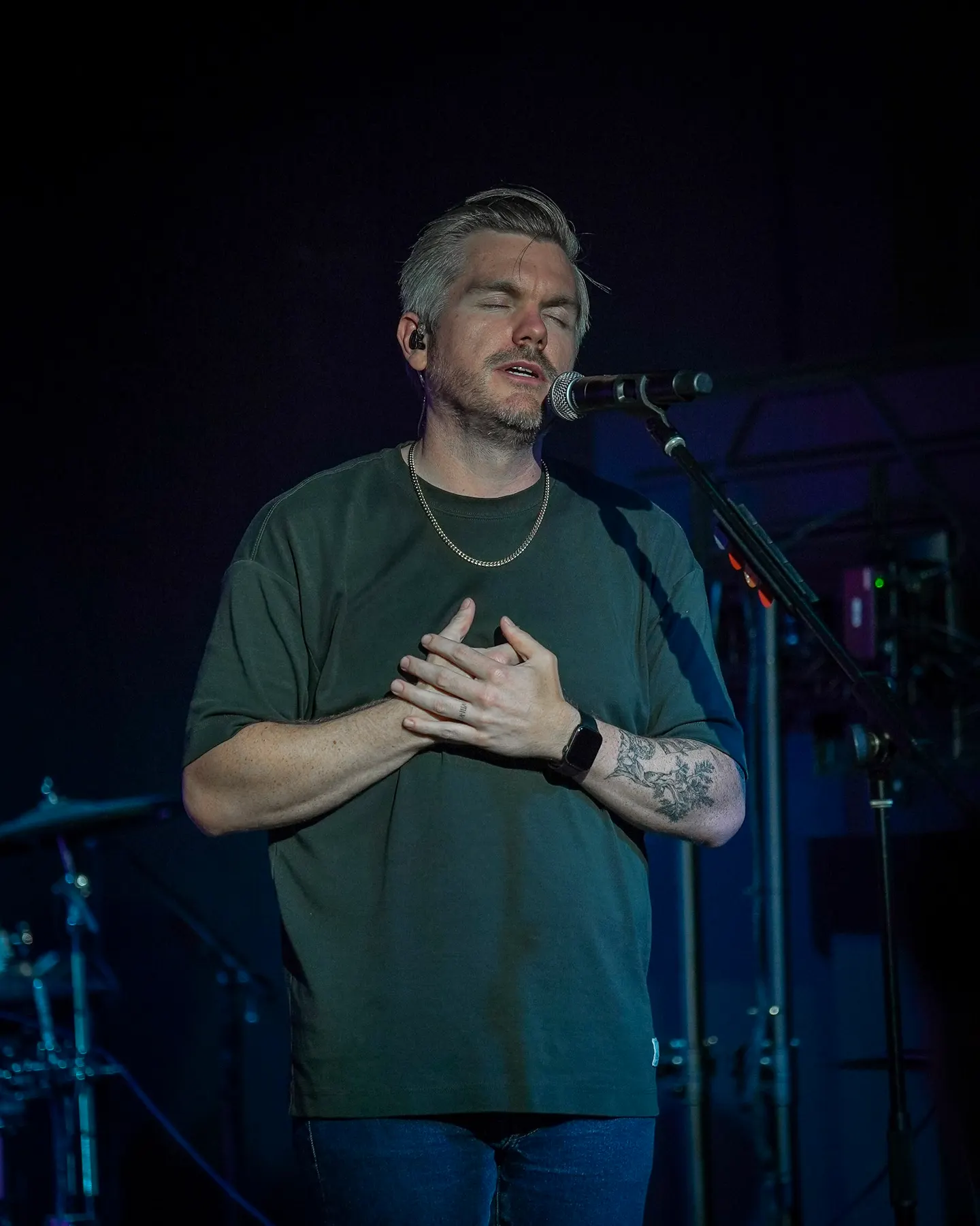 A man singing with his hand on his chest