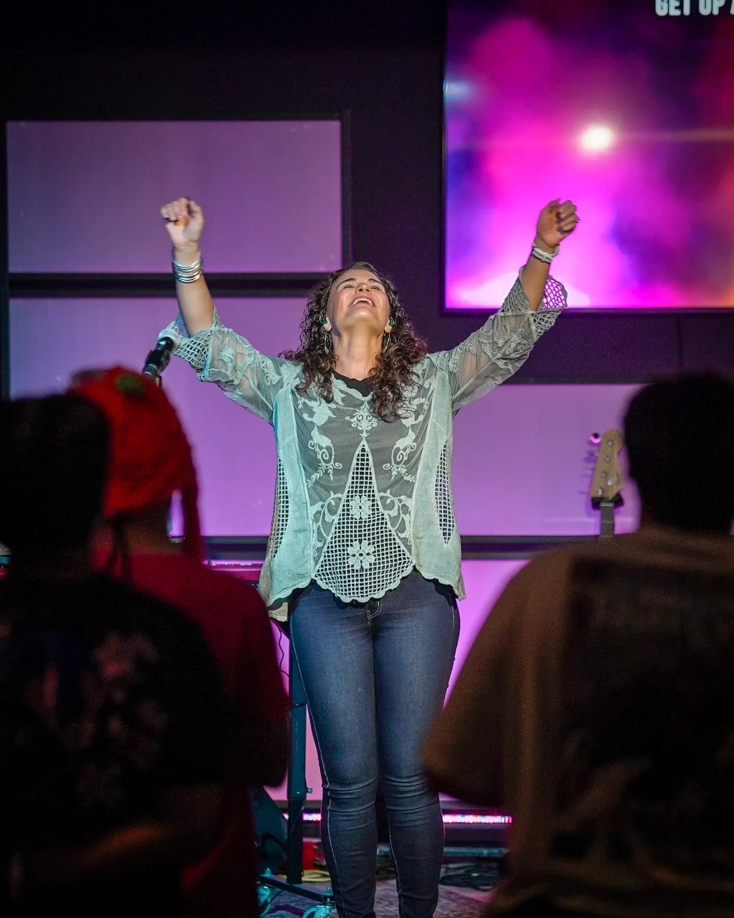 A woman worshipping with both fists raised