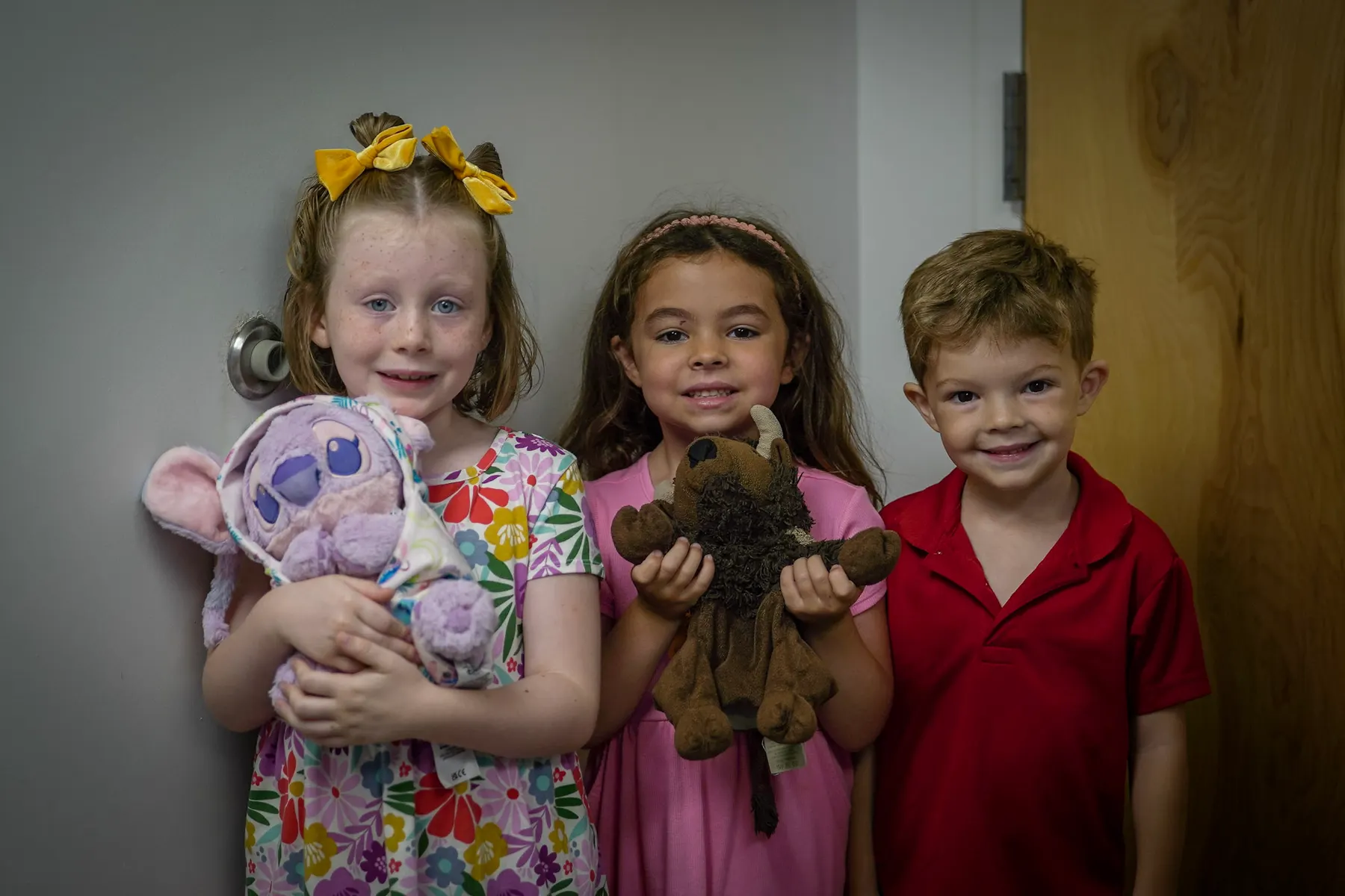 Three children holding handmade crosses