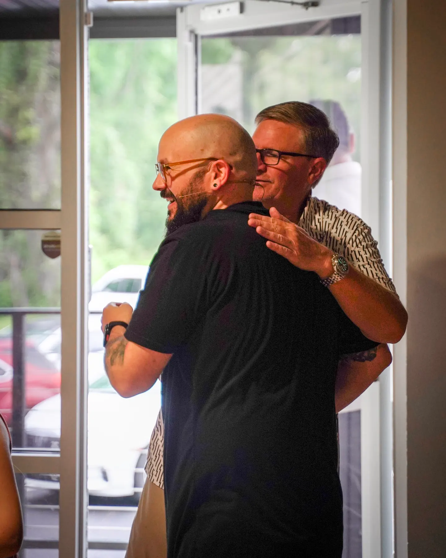 Two people greeting each other at the door